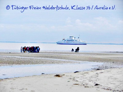 Wattenmeer auf Sylt mit Schülern und einem Schiff auf der Nordsee