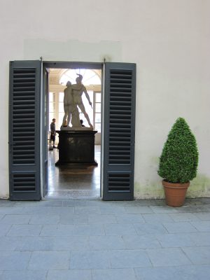 Statue hinter halb geöffneter Flügeltür der Villa Charlotta